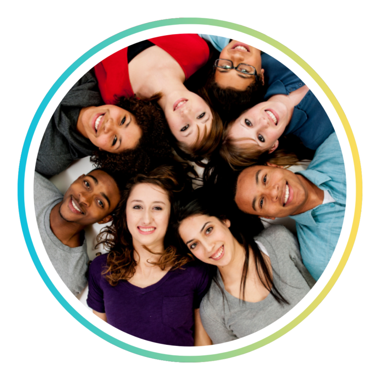 A group of students laying down in a circle, smiling a the camera.