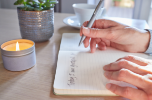 Close-up of someone writing in a journal.